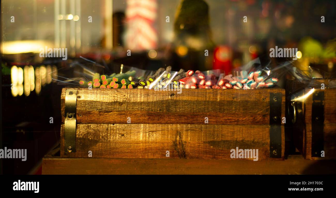Bunte, helle Süßigkeitenmarmelade in einer Holzkiste auf der Theke hinter dem Glas. Stockfoto