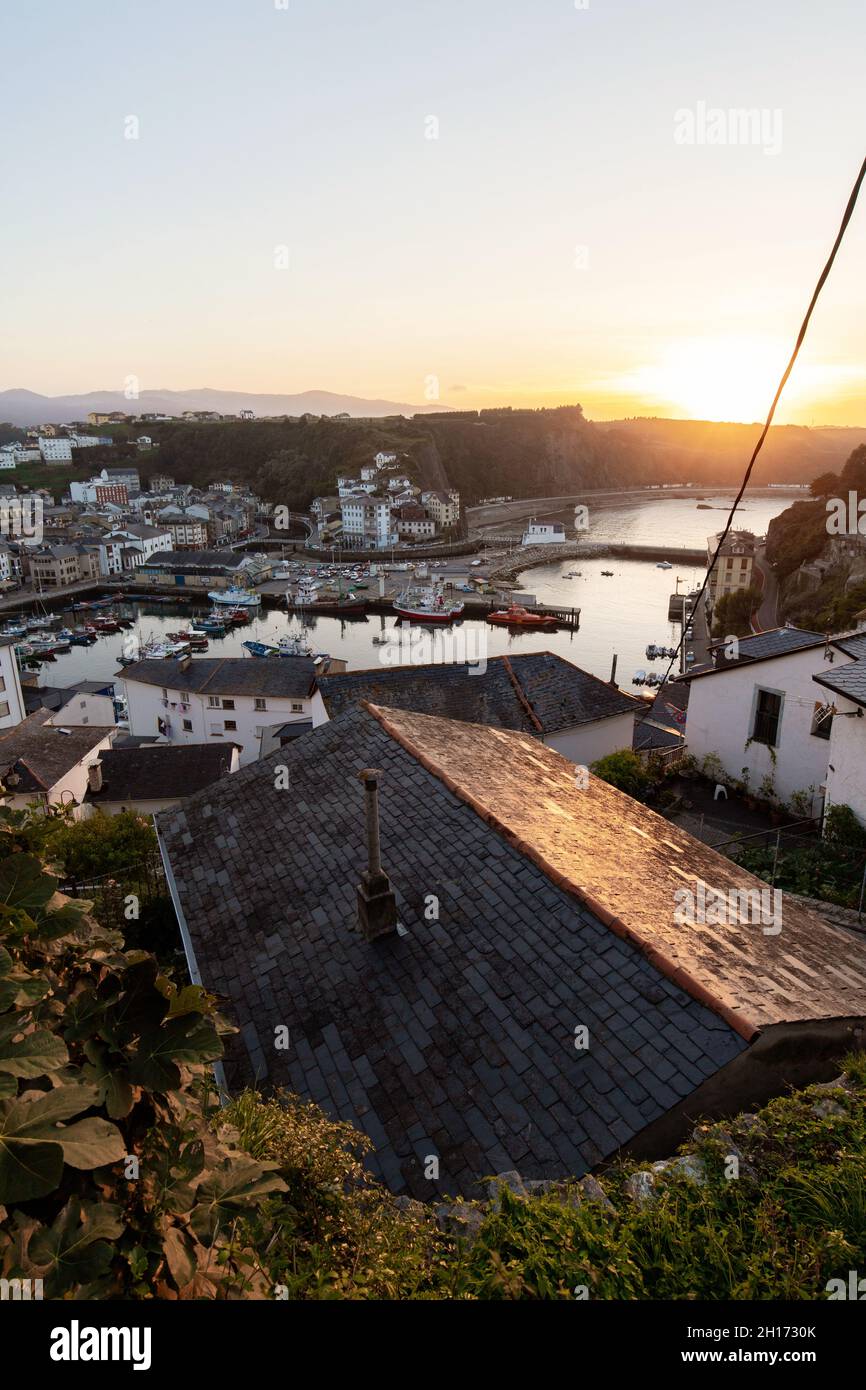 Von oben von Wohnhäusern in Küstengebiet auf grasbewachsenen Ufer in der Nähe von ruhigem Wasser mit verschiedenen Booten in Asturien entfernt Stockfoto