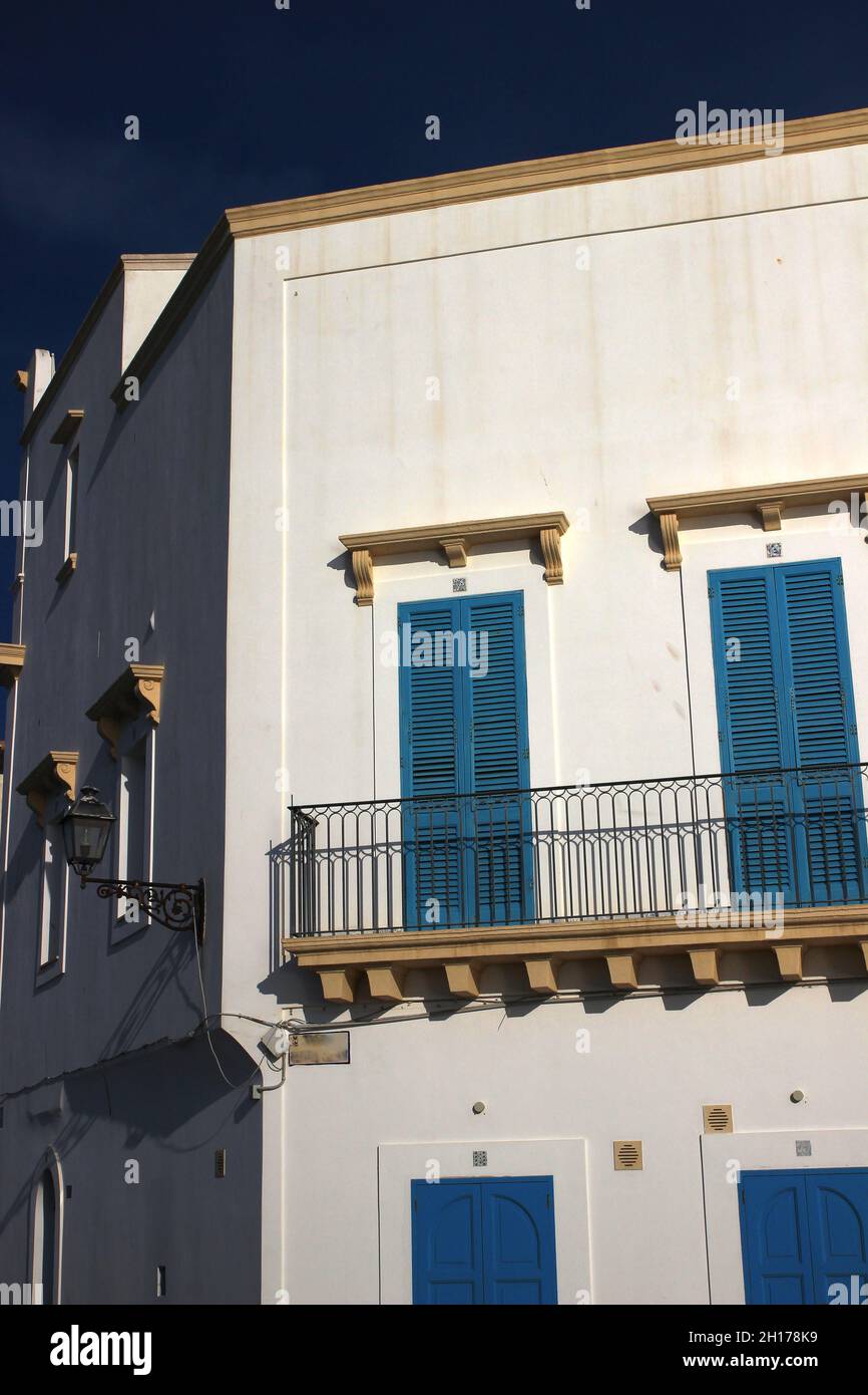 In der Altstadt von Gallipoli spiegelt die weiße Fassade eines Hauses das Licht einer schönen Oktobersonne wider (Apulien, Italien) Stockfoto