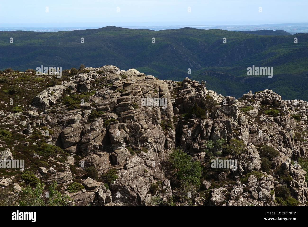 Die kleine Silhouette eines Wanderers ist auf einem Bergrücken von der Caroux-Hochebene in der Nähe der Schluchten von Colombières (Hérault, Haut Languedoc, Frankreich) zu sehen. Stockfoto