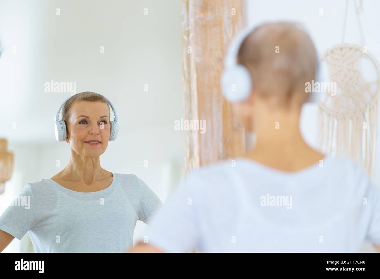 Sportliche ältere Frau, die sich im Spiegel bewundert. Stockfoto