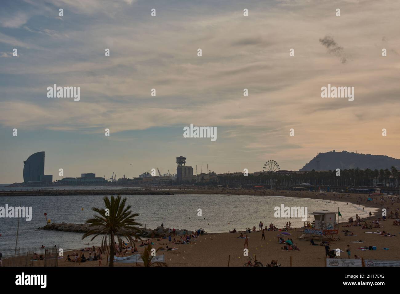 Menschen am Strand von Somorrostro bei Sonnenuntergang, Barcelona, Katalonien, Spanien Stockfoto