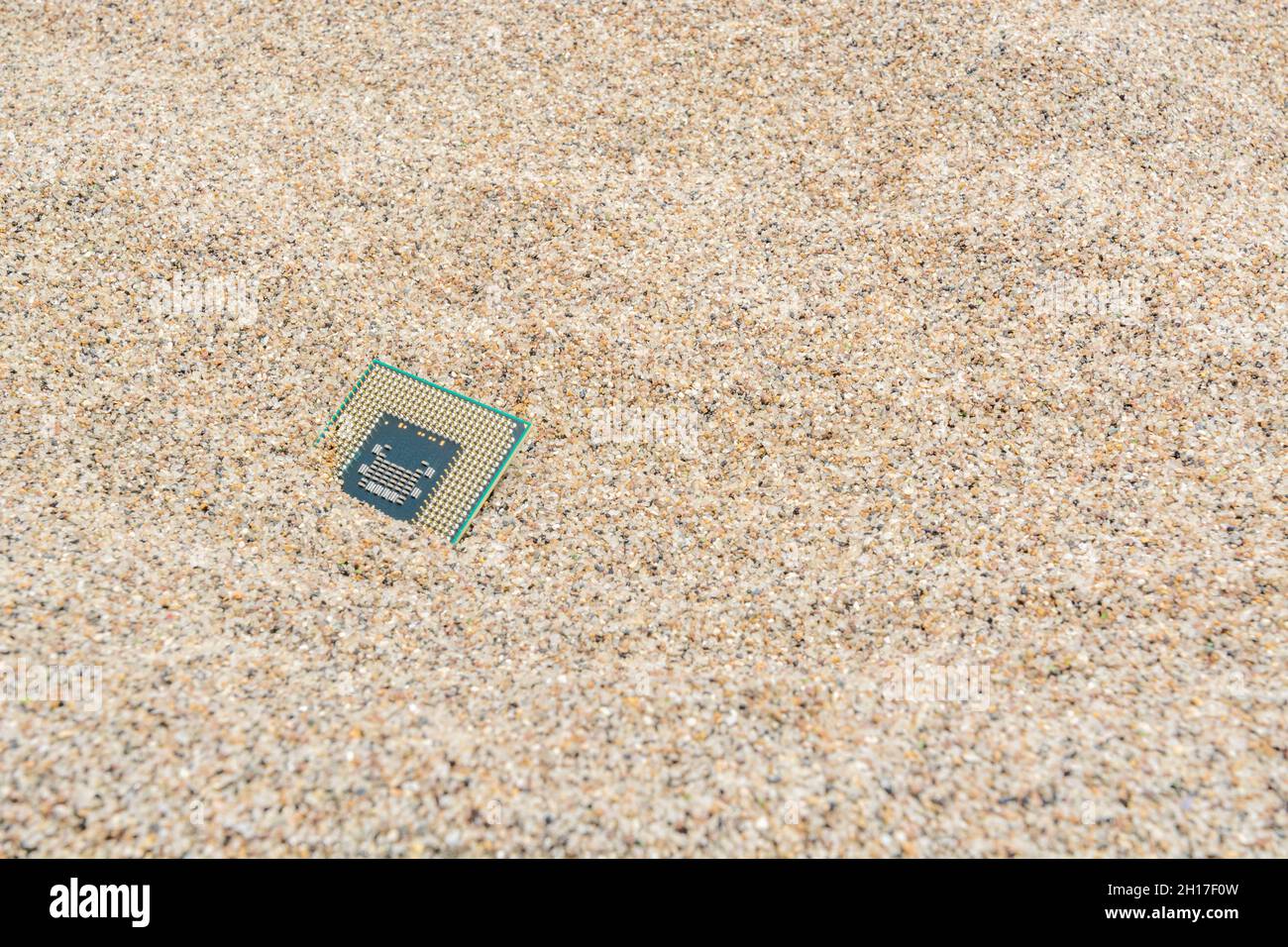 Uralte Computer-CPUs, die in einem Sandhaufen für Computer-Friedhof, Legacy-Computing begraben sind. Intel Mobile Computing Merom cpu vorhanden. Stockfoto