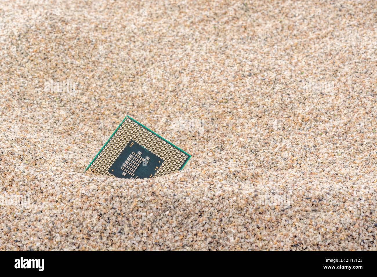 Uralte Computer-CPUs, die in einem Sandhaufen für Computer-Friedhof, Legacy-Computing begraben sind. Intel Mobile Computing Merom cpu vorhanden. Stockfoto