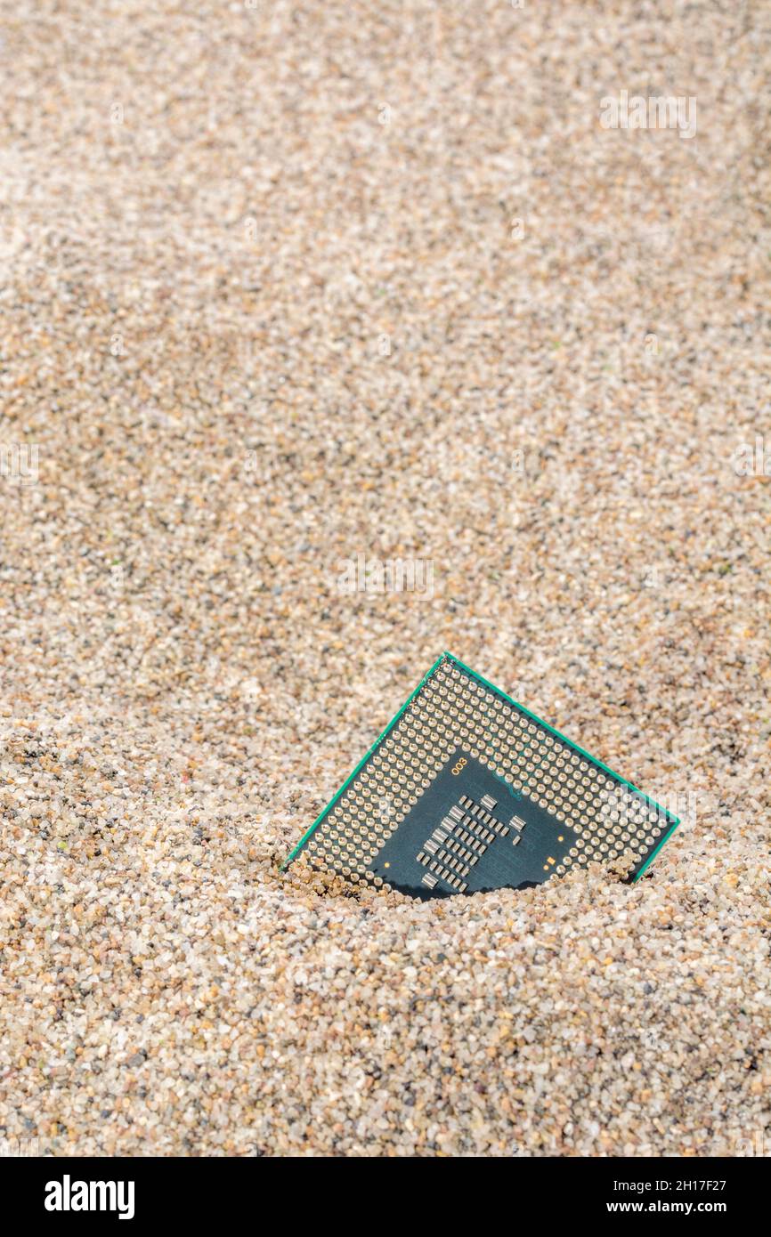 Uralte Computer-CPUs, die in einem Sandhaufen für Computer-Friedhof, Legacy-Computing begraben sind. Intel Mobile Computing Merom cpu vorhanden. Stockfoto