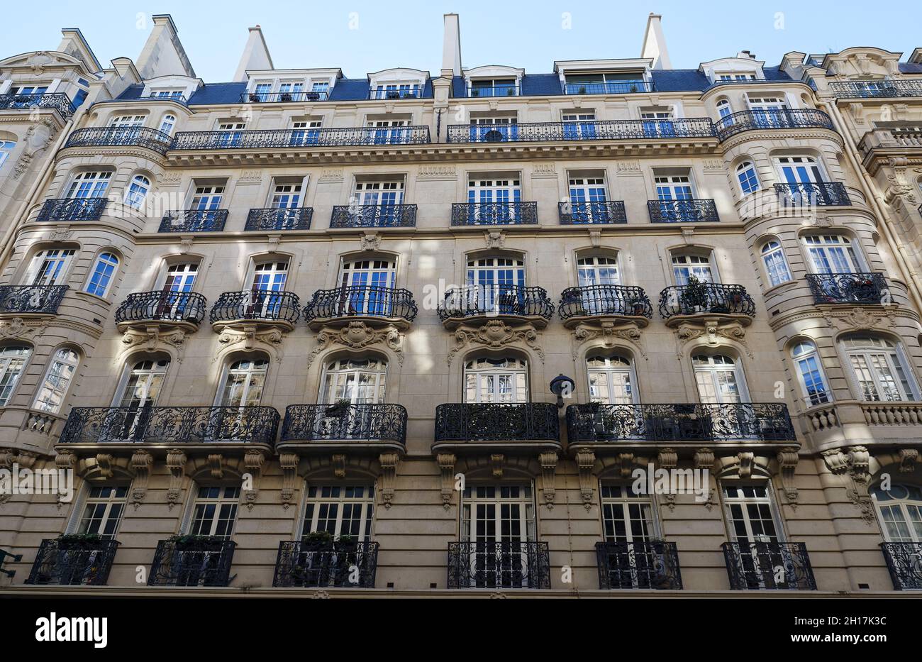 Die Fassade eines traditionellen französischen Hauses mit typischen Balkonen und Fenstern. Paris. Stockfoto