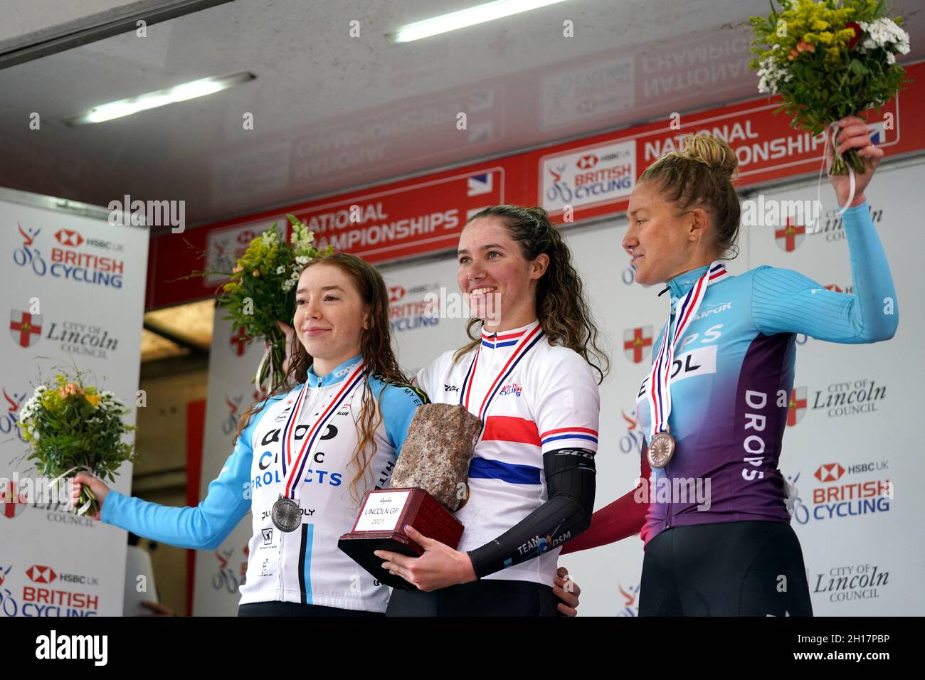 Pfeiffer Georgi vom Team DSM (Mitte) feiert den Sieg beim Women's Road-Rennen, neben Josie Nelson (links), dem zweitplatzierten Isorex NoAqua Ladies Cycling Team, und dem drittplatzierten Drops-Le Col, unterstützt von Tempurs Joscelin Lowden, während des British Cycling National Championships Road Race durch Lincoln. Bilddatum: Sonntag, 17. Oktober 2021. Stockfoto