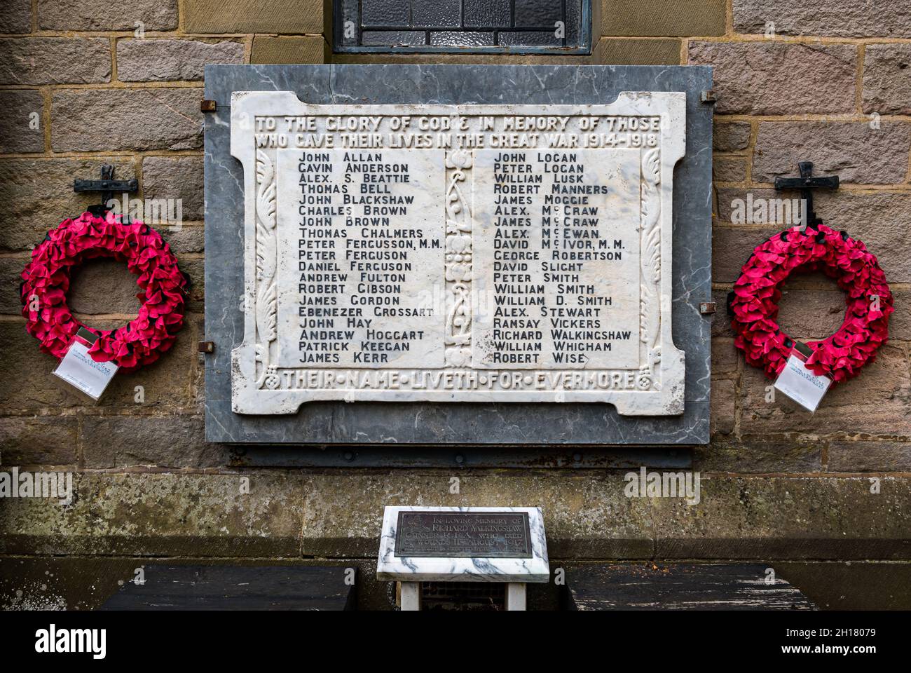 Namen toter Soldaten auf Marmordenkmal aus dem Ersten Weltkrieg an der Kirchenwand mit Mohnkränzen, Ormiston Dorfkirche, East Lothian, Schottland, Großbritannien Stockfoto