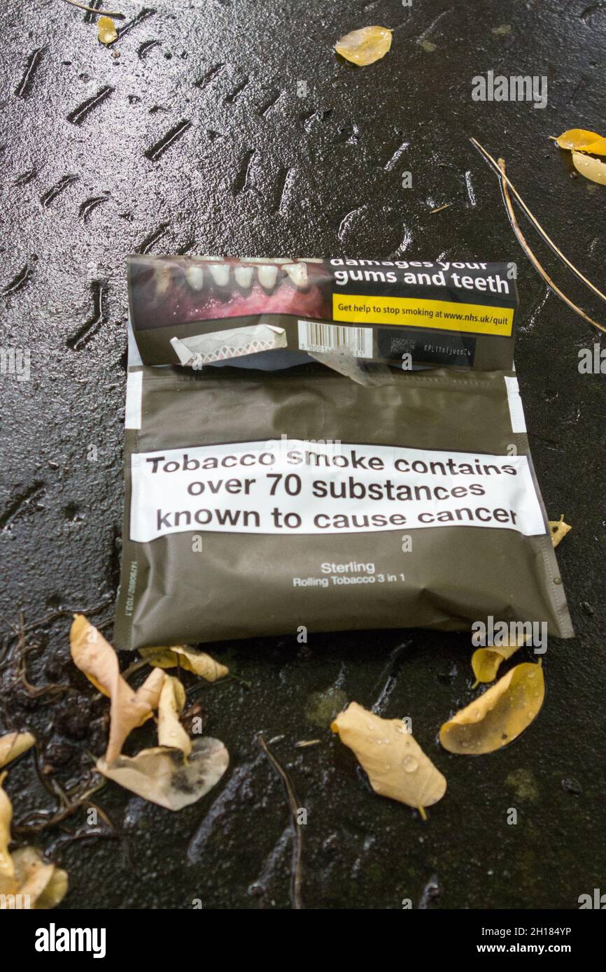 Grafische Gesundheitswarnung auf rollenden Tabakverpackungen, die auf einem alten Grab auf einem Friedhof in London ruhen Stockfoto