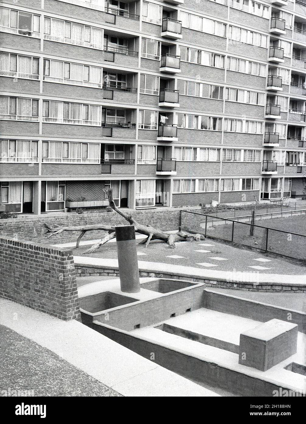 1960er Jahre, historisch, ein betonter und ummauerter Spielplatz außerhalb eines großen wohngebiets des rates, Churchill Gardens in Pimlico, inneres London, England, Großbritannien. Zwischen 1948 und 1962 erbaut, um viktorianische Terrassen zu ersetzen, die im Blitz des 2. Weltkrieges beschädigt wurden, war dies ein riesiges Anwesen an sozialem Wohnraum mit 32 Turmblöcken, die 1,600 Häuser bereithalten. Außerhalb der Wohnungen, ein ummauertes Gehäuse mit einem betonierten Spielplatz und Sandkasten in Form eines Bootes. Stockfoto