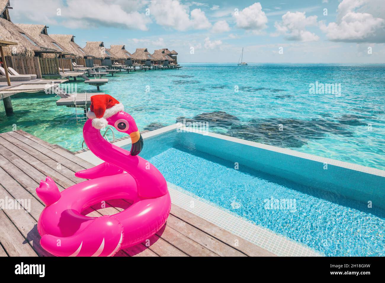 Luxus-Weihnachts-Swimmingpool-Resort mit flamingo-Pool-Schwimmer mit weihnachtshut. Juli in Winterferien Karibik Reiseziel Reise Hintergrund Stockfoto