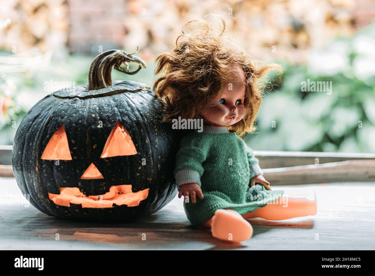 Nahaufnahme eines geschnitzten Kürbisses mit einer alten Puppe. Halloween  Deko Konzept Stockfotografie - Alamy
