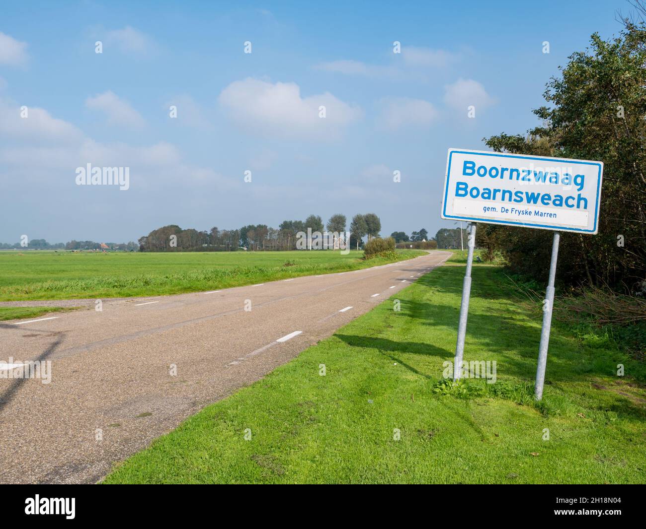 Zweisprachiges Ortsnamen-Zeichen in Friesisch und Niederländisch des Dorfes Boornzwaag durch Polderstraße, Friesland, Niederlande Stockfoto