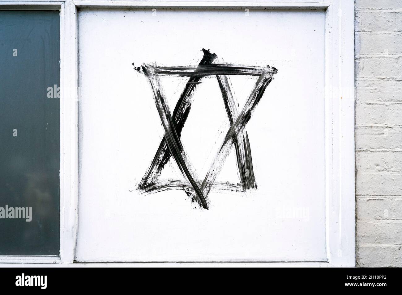 Davidstern Hexagramm-Graffiti in schwarzer Farbe auf weißem Paneel Stockfoto