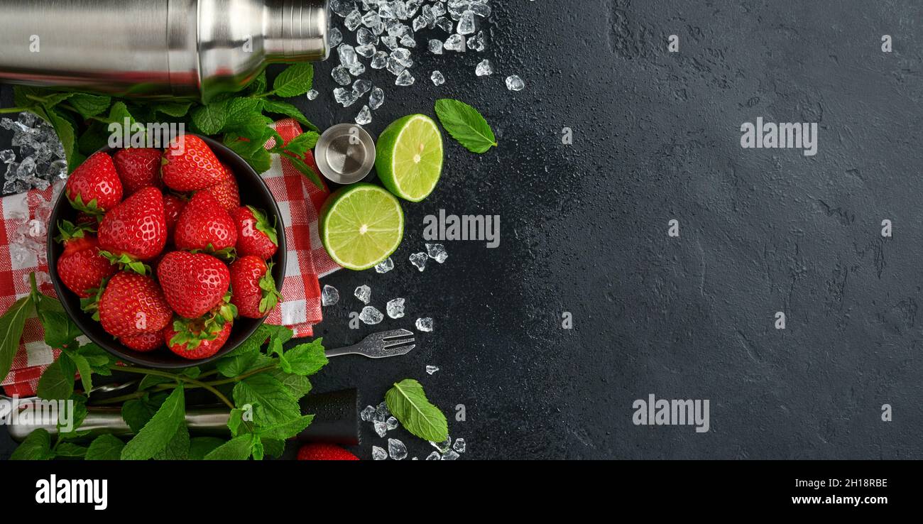 Lebensmittel Frische Zutaten für die Herstellung von Limonade, infundiert entgiftendes Wasser oder Cocktail. Erdbeeren, Limette, Minze, Basilikum, Rohrzucker, Eiswürfel und Shaker auf Blac Stockfoto