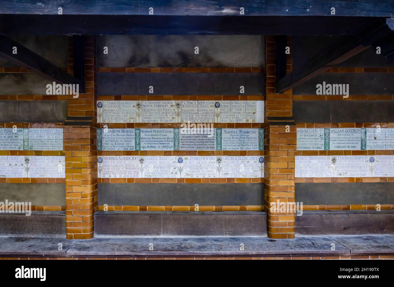 Geflieste Widmungsplakate mit Tribut an tapfere, lebensrettende Helden im Watts Memorial to Heroic Self Sacrifice im Postman's Park in London EC1 Stockfoto