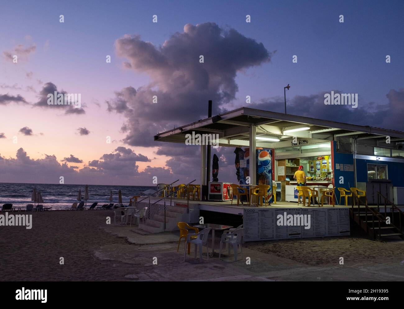 Strandcafe am Leuchtturm von Paphos in der Abenddämmerung, Paphos, Zypern. Stockfoto