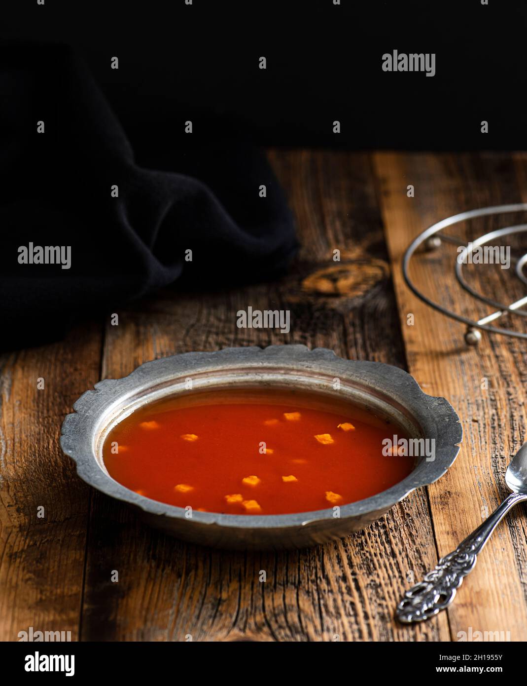 Tomatensuppe auf einer Kupferplatte. Suppe auf Holztisch. Stockfoto