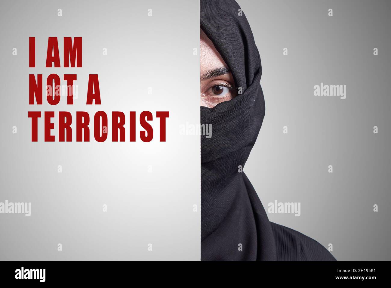 Junge muslimische Frauen, die einen Teil des Gesichts bedecken und sagen: Ich bin kein Terrorist. Muslimische Mädchen in traditioneller Nikab-Kleidung. Symbol der Diskriminierung Stockfoto