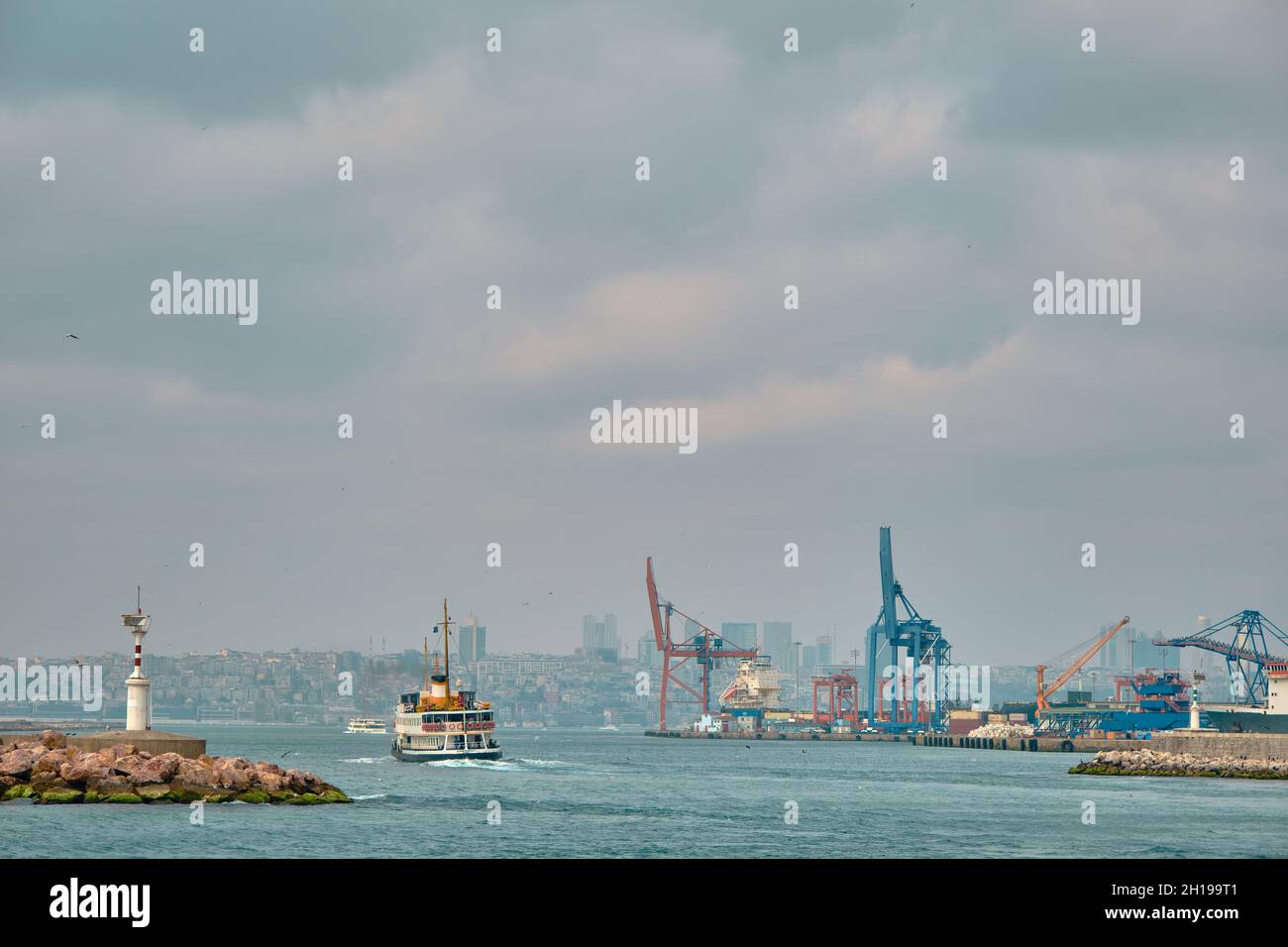 Bosporus von istanbul mit Fußgängerfähre und Schiff mit haydarpasa Hafen und Hafen mit Seekränen an bewölkten und regnerischen Tagen. Stockfoto