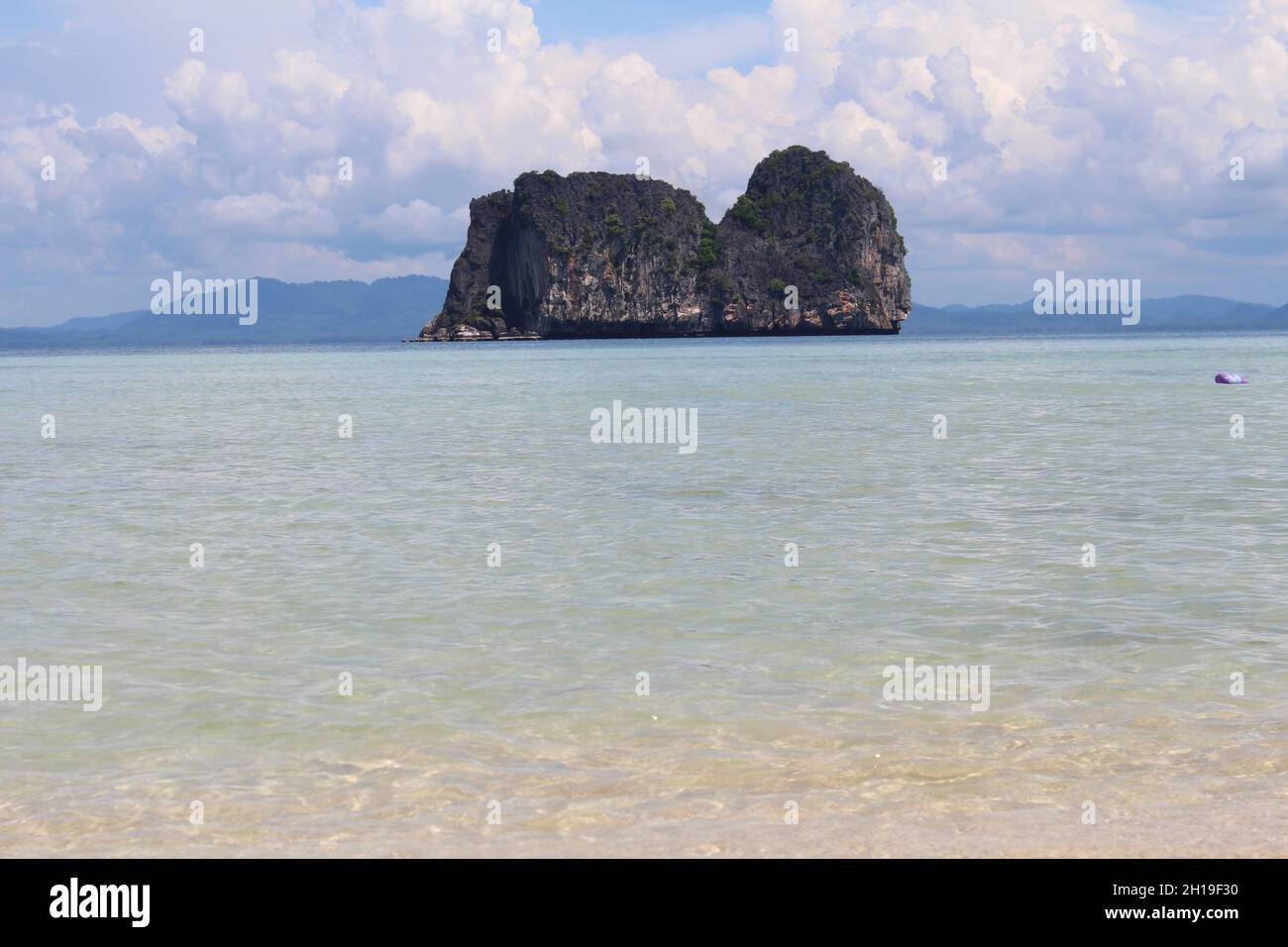 Der malerische Blick auf die Insel Ko Ngai über das Meerwasser vor dem wolkigen Himmel in Thailand Stockfoto