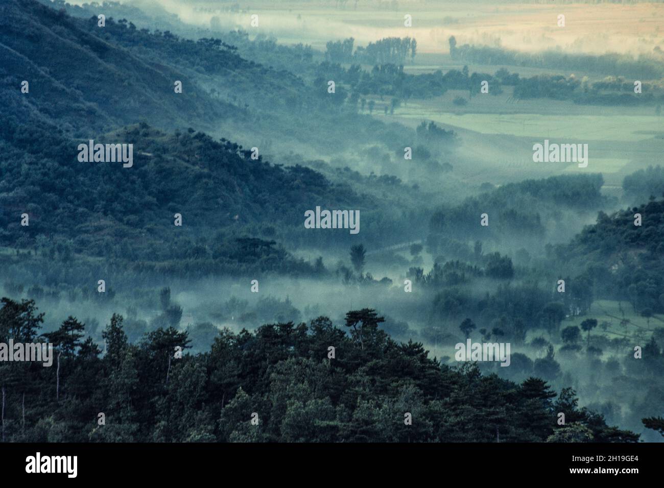Morgennebel im Mutianyu-Tal unterhalb der Chinesischen Mauer. Stockfoto
