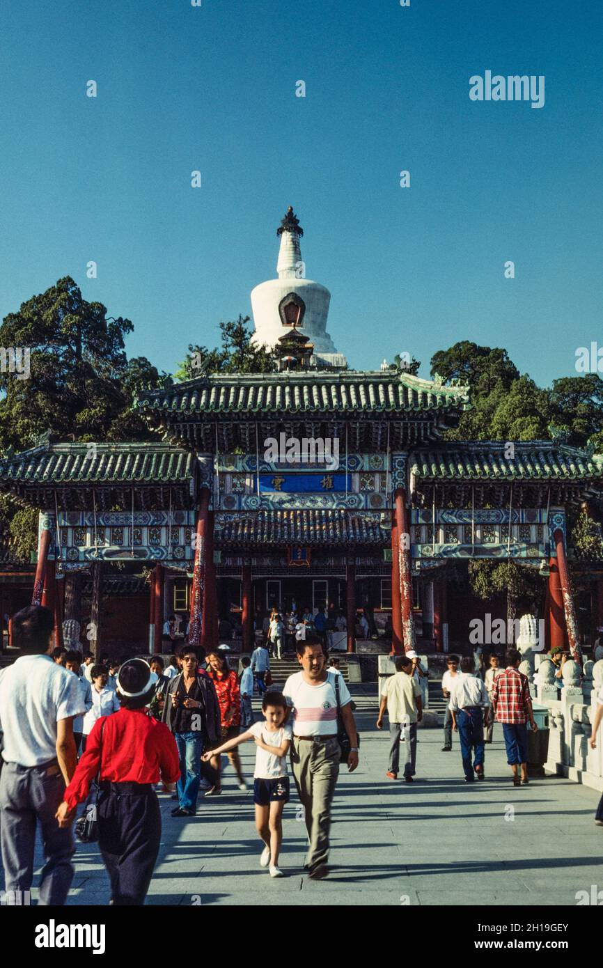 Chinesische Touristen und Tor zum Beihai Park und der Weißen Dagoba auf Jade Flower Island. Peking, China. Stockfoto