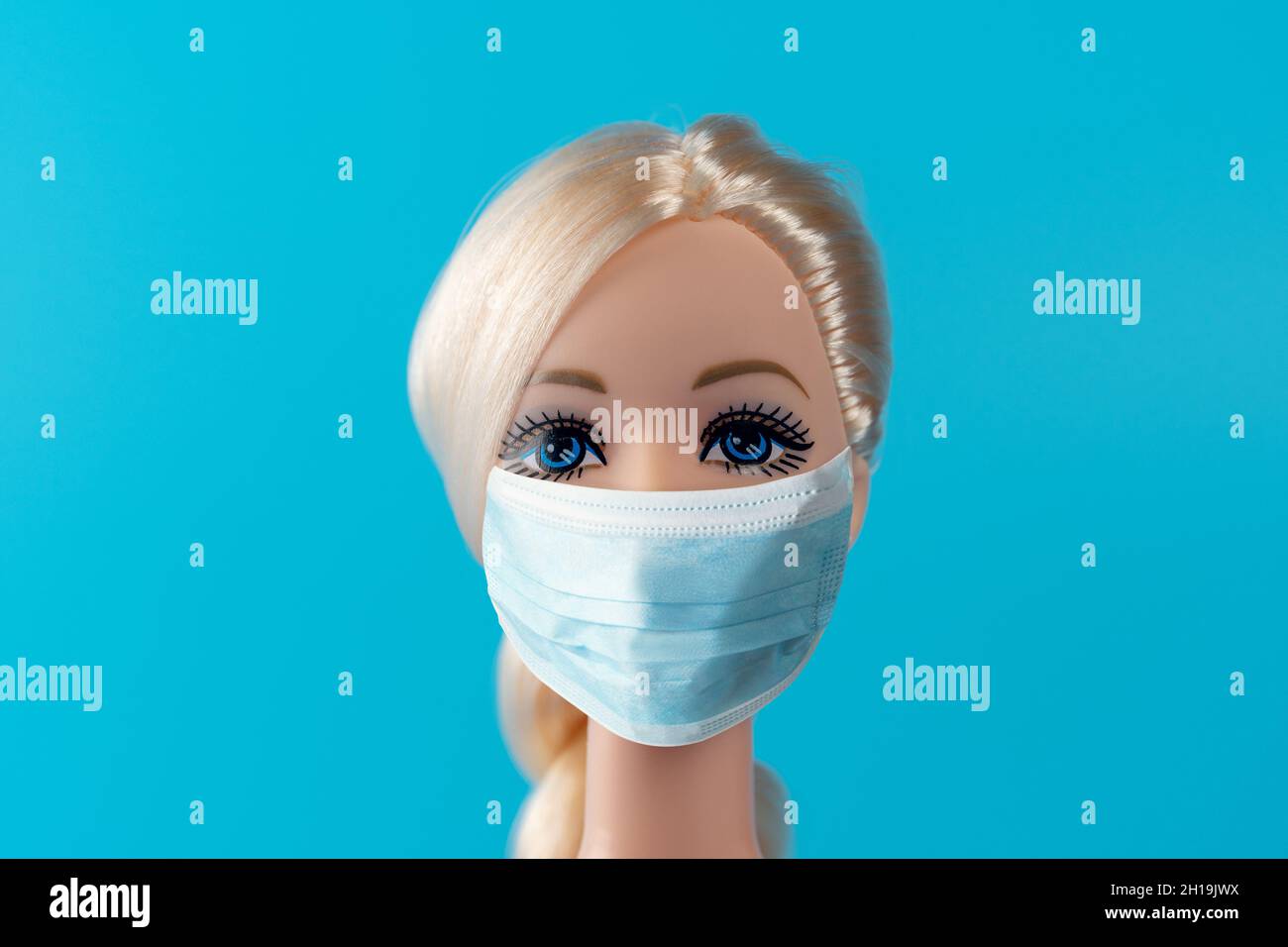 Heraklion, Griechenland, 13. März 2020: Kreative Komposition mit Puppe mit Virusmaske. Minimaler Ausbruch des Corona-Virus. Urlaubskonzept. Stockfoto
