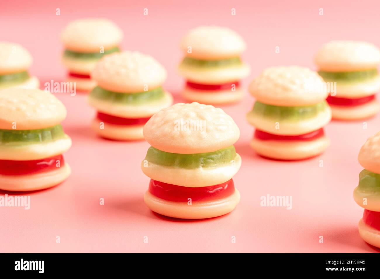 Bunte Süßigkeiten Hamburger auf rosa Hintergrund. Minimales Lebensmittelkonzept. Stockfoto