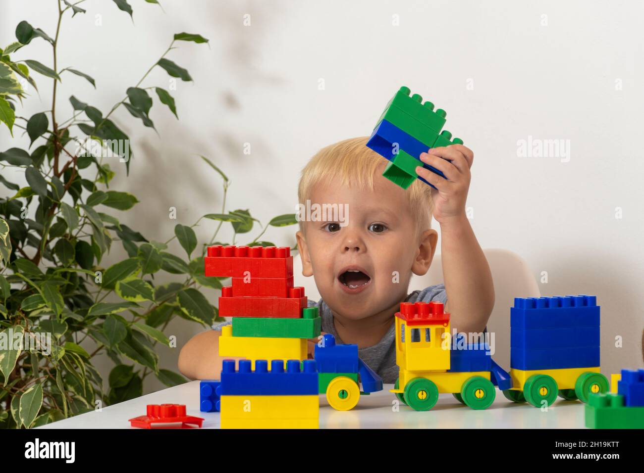 Kind spielt mit bunten pädagogischen Bausteinen. Kleiner Junge mit kreativem Spielzeug. Spiele für kleine Kinder. Kind auf weißem Hintergrund Stockfoto