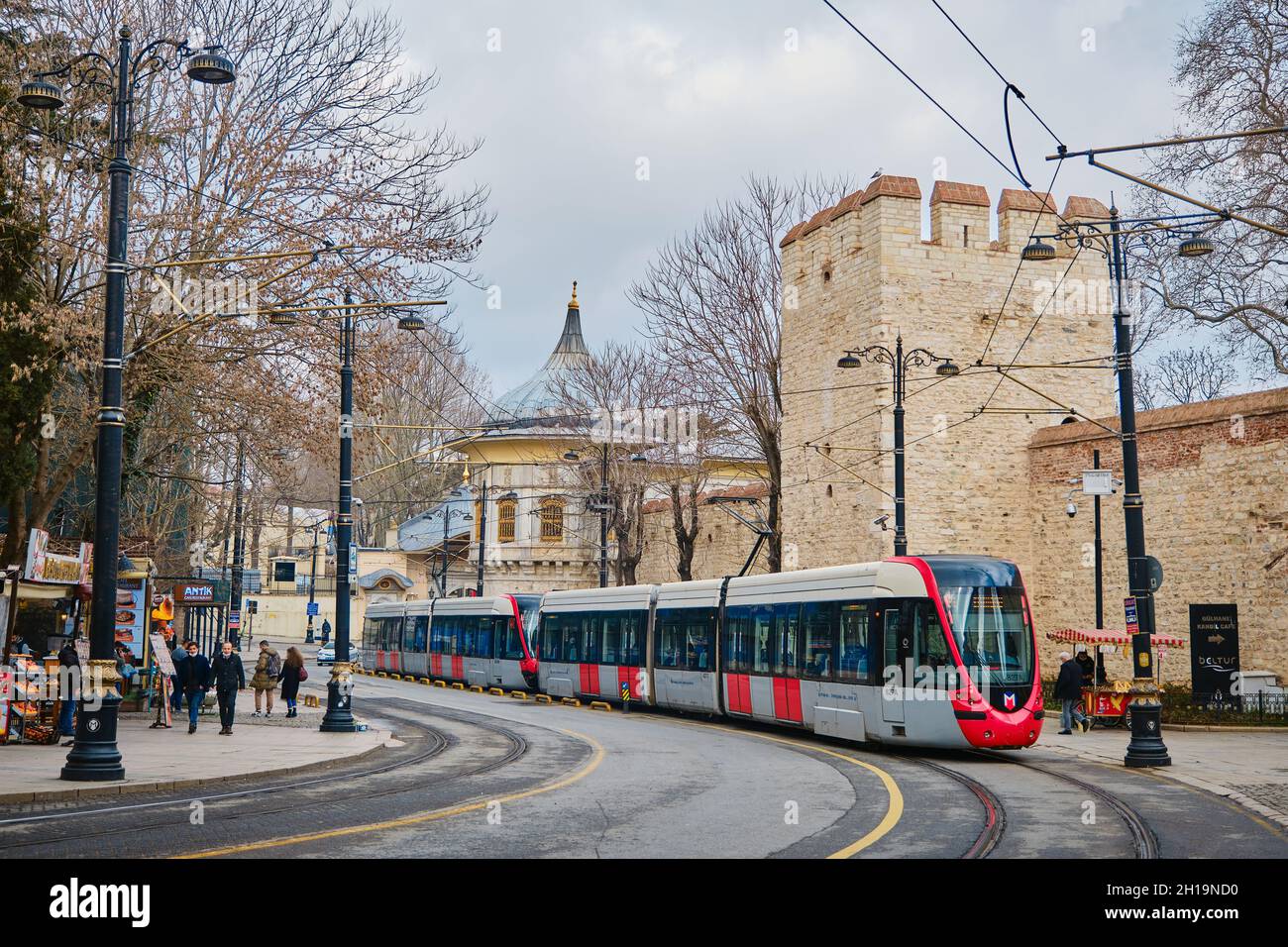 04.03.2021. istanbul türkei. Bei regnerischem und bewölktem Wetter fährt die Straßenbahn in der Nähe der Hagia Sophia-Moschee mit dem Straßenverkäufer durch Stockfoto