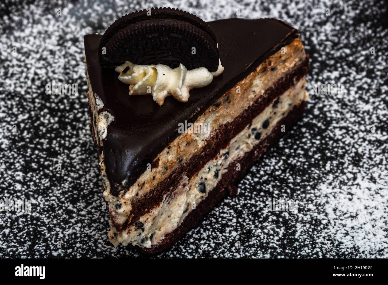 Eine Nahaufnahme eines Schokoladenmousse-Dessertkuchens auf weißem pulverschwarzem Hintergrund; Kochkonzept Stockfoto