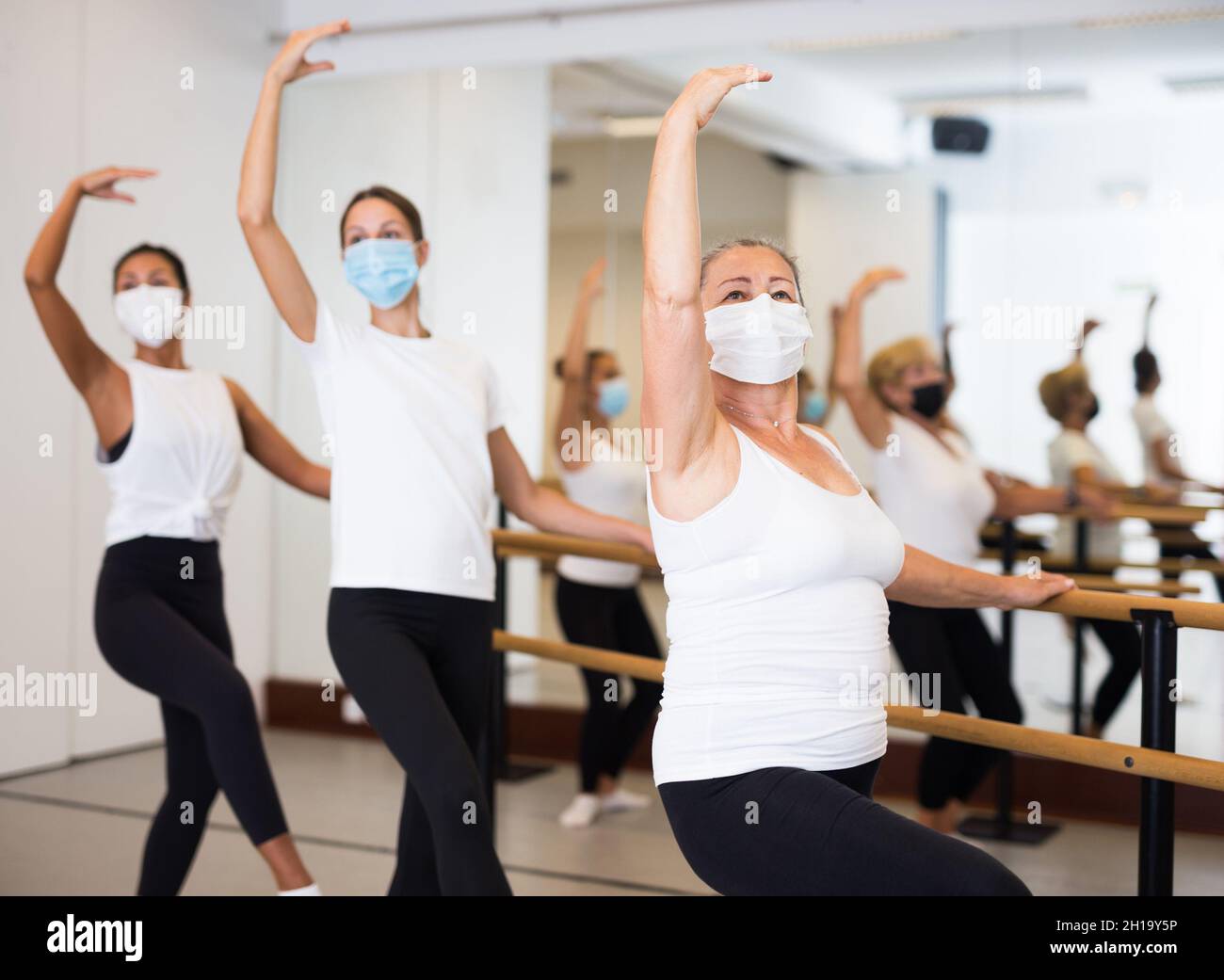 Gruppe von Frauen in Masken tun Ballett Tanz bewegt Stockfoto