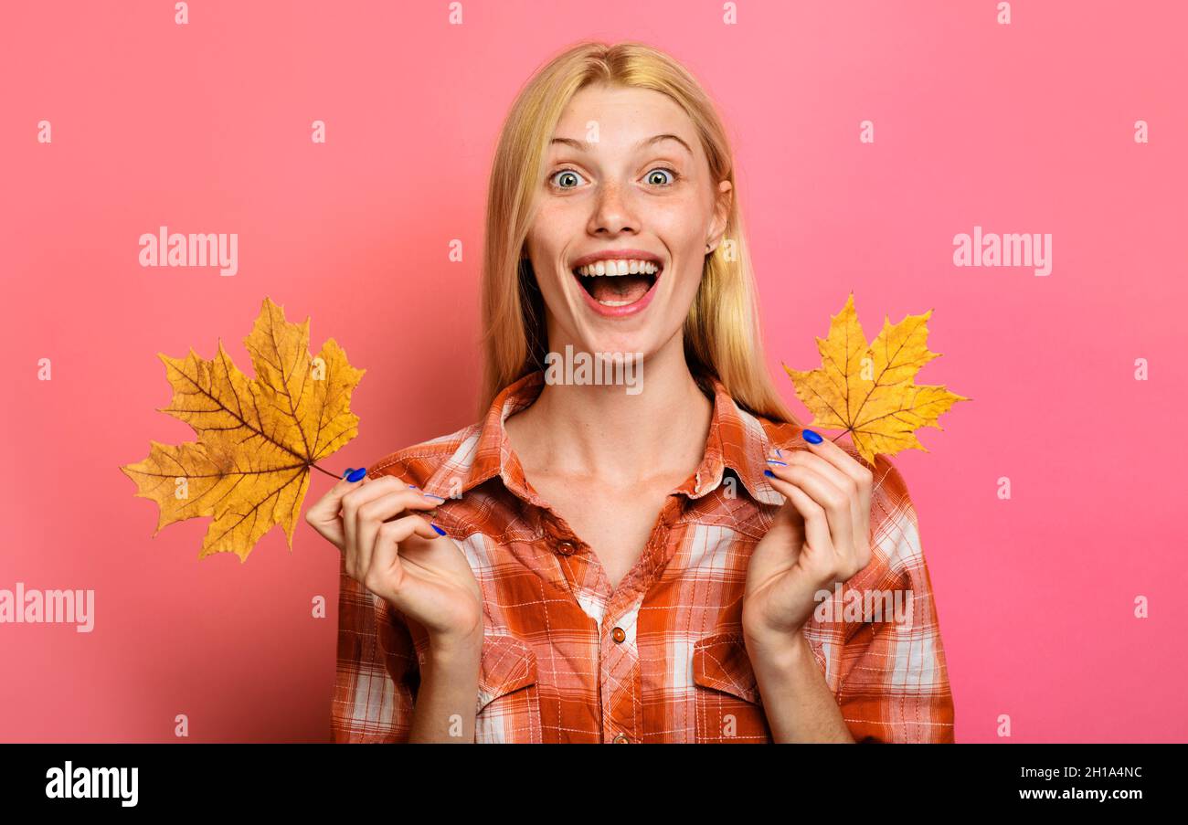Herbstliche Stimmung. Lächelndes Mädchen in lässiger Kleidung mit Ahornblättern. Modetrends für den Herbst. Herbstverkäufe Stockfoto