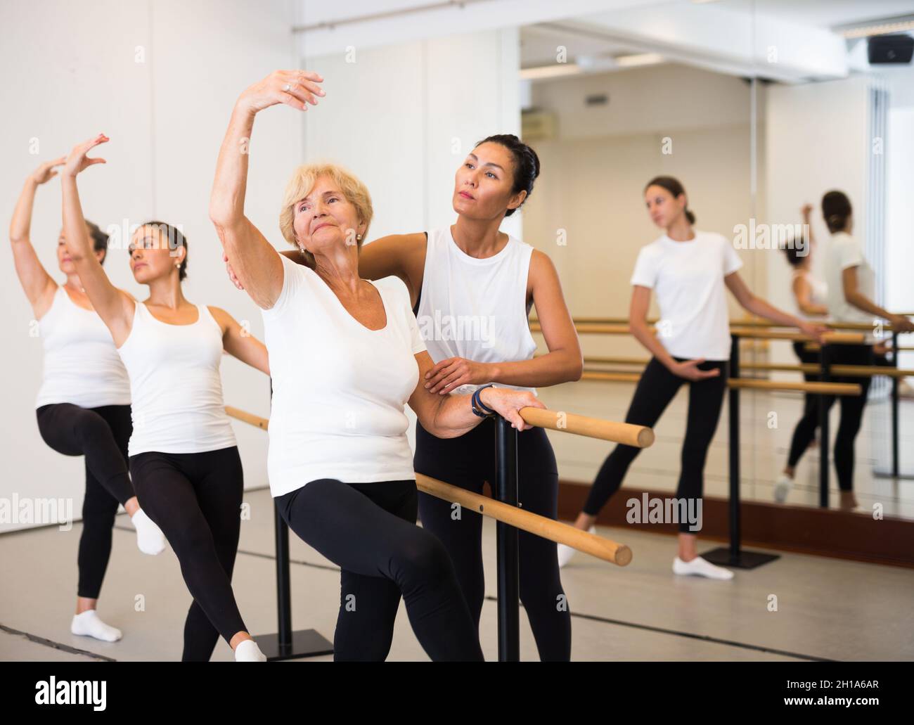 Verschiedene ältere Frauen trainieren Ballettbewegungen mit Trainer Stockfoto