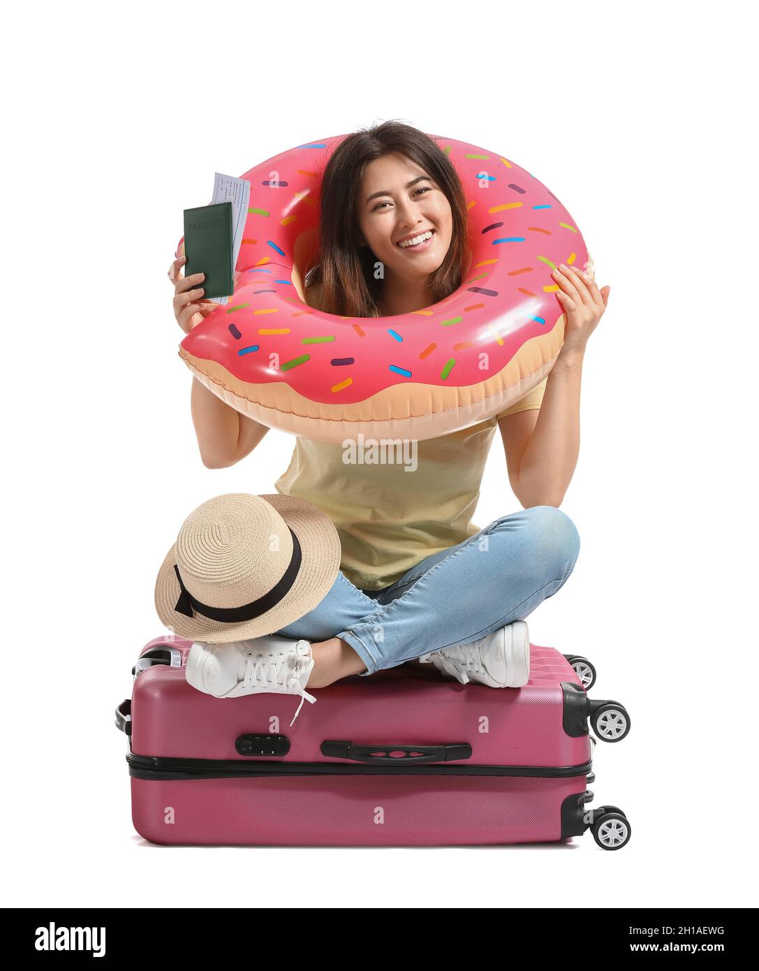 Junge Frau mit aufblasbarem Ring und Reisepass auf weißem Hintergrund Stockfoto