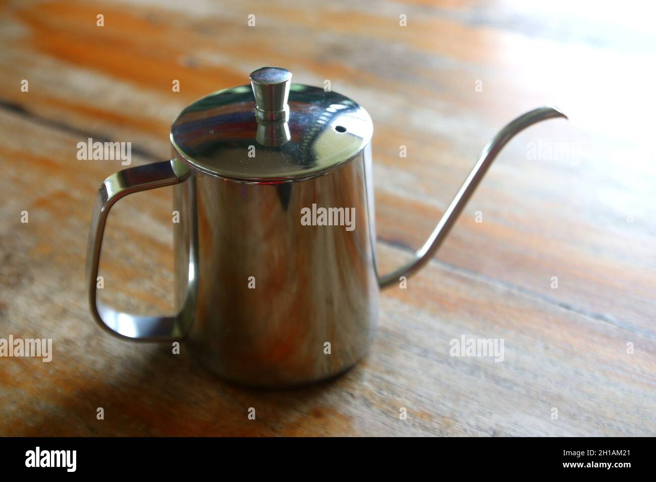 Edelstahl-Kaffeetropfkessel-Kanne auf Holztisch Stockfoto