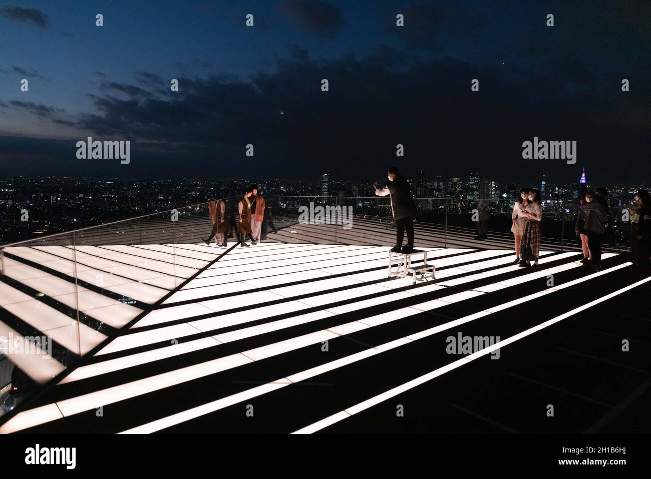 Besucher des Shibuya Sky fotografieren im oberen Stockwerk der Aussichtsplattform während des Sonnenuntergangs.Shibuya Sky ist eine neue Attraktion für inländische und internationale Touristen mit einem großartigen Blick über Tokio. Stockfoto