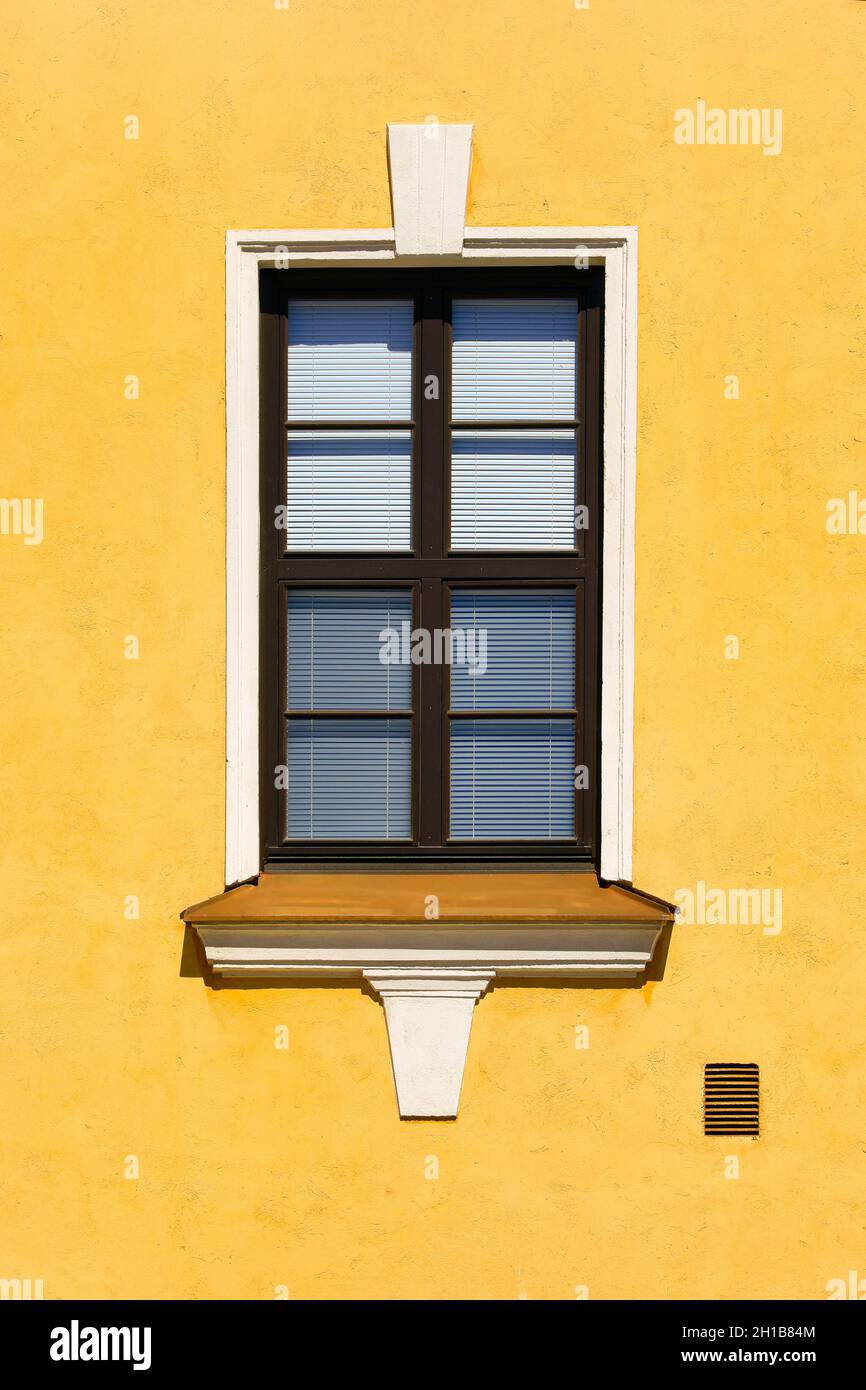 Wunderschönes Fenster an der gelben Gebäudefassade. Klassische Architektur. Stockfoto
