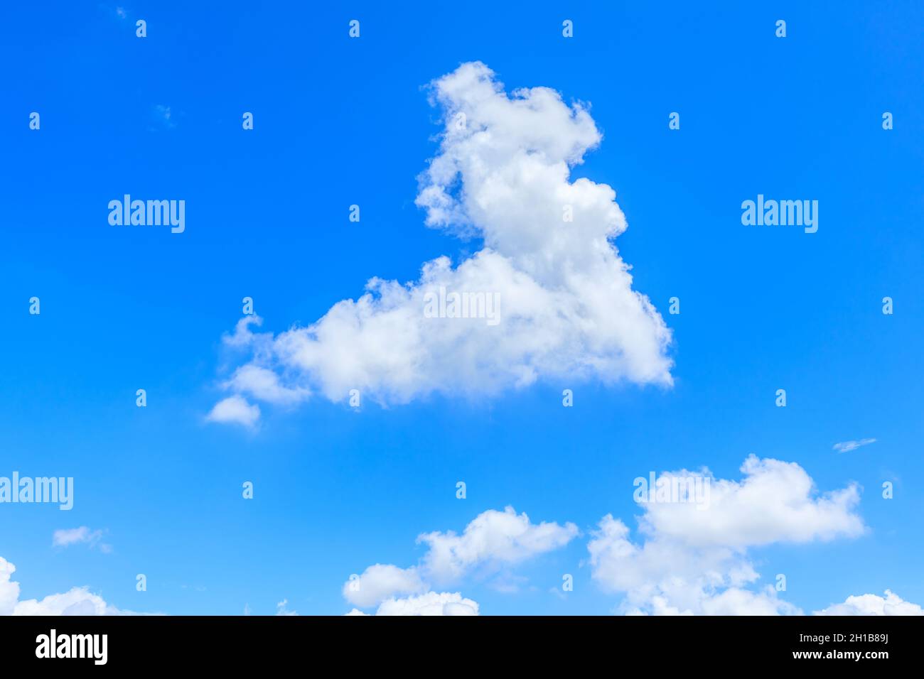 Seltsam geformte weiße Wolken am blauen Himmel. Stockfoto