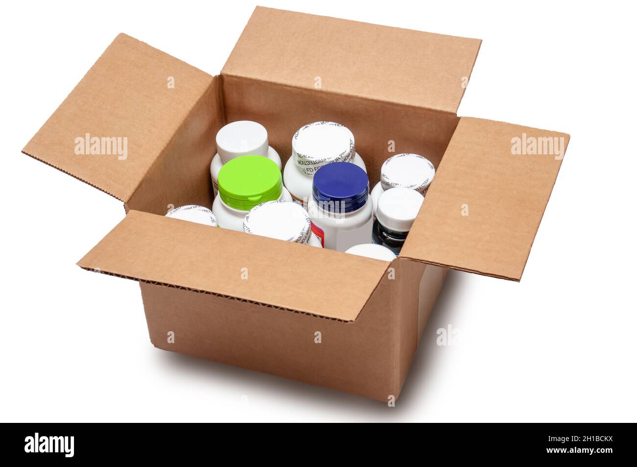 Offener Karton mit Flaschen von Medikamenten und Vitaminen isoliert auf weißem Hintergrund. Konzept für die Tür-zu-Tür-Lieferung von Medikamenten während des Quars Stockfoto