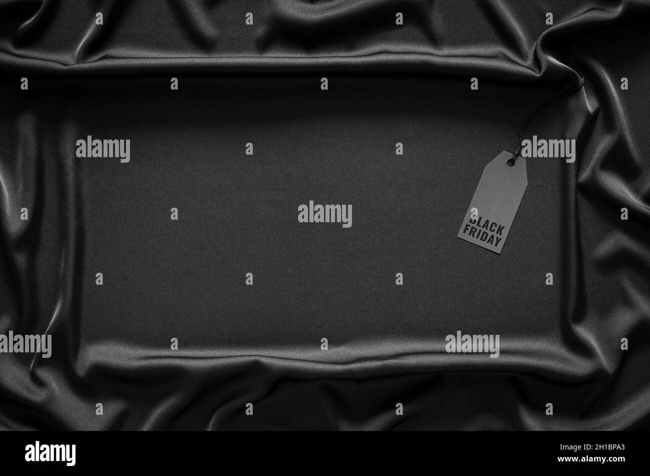 Ein schwarzer Preisschild auf schwarzem, glattem und welligen Tuch mit Platz für Text. Black Friday Konzept. Stockfoto