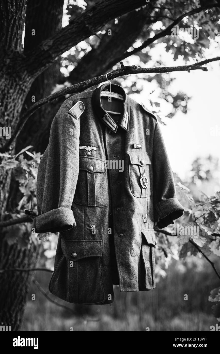 Mantel Tunika des Zweiten Weltkriegs Deutsche Wehrmacht Infanterie Soldat hängend an Einem Hanger auf Holz im Freien im Lager. 2. Weltkrieg 2-mal. Uniform Deutscher Soldaten Stockfoto