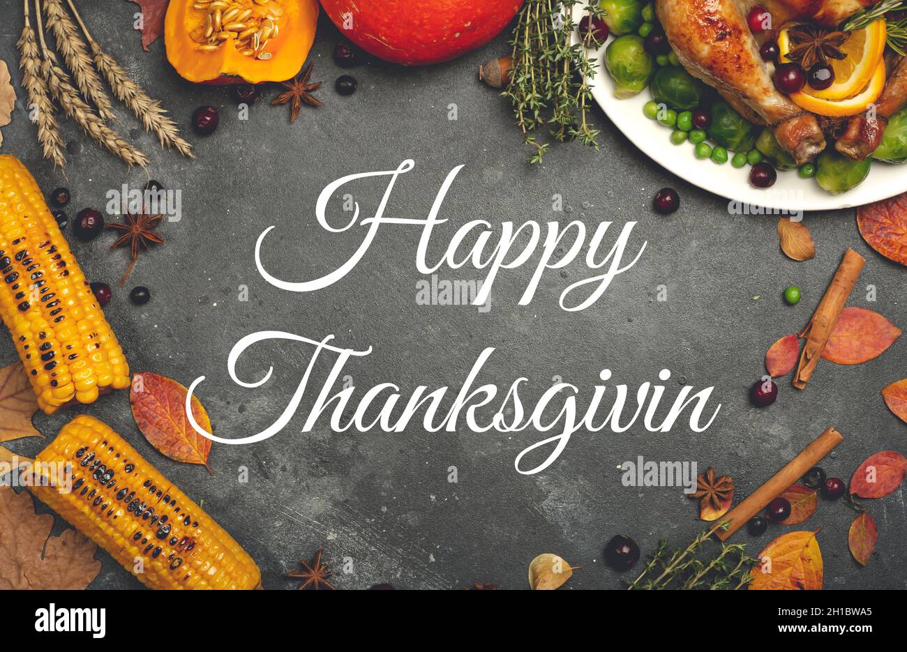 Happy Thanksgiving Schriftzug auf festlichem Dinner-Hintergrund. Speisen im Hintergrund mit saisonalen Herbstspezialitäten zum Thanksgiving Day. Gebratenes Huhn mit Kürbis, Gemüse und Herbstdekor. Hochwertige Fotos Stockfoto