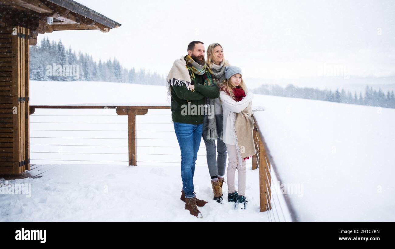 Familie mit kleiner Tochter auf Terrasse im Freien, Urlaub im Winter Natur. Stockfoto