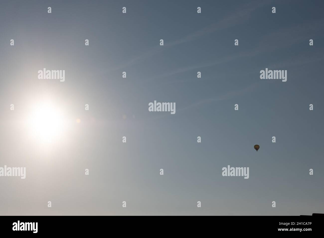 Landschaft Heißluftballon, der im Morgengrauen am blauen Himmel fliegt Stockfoto