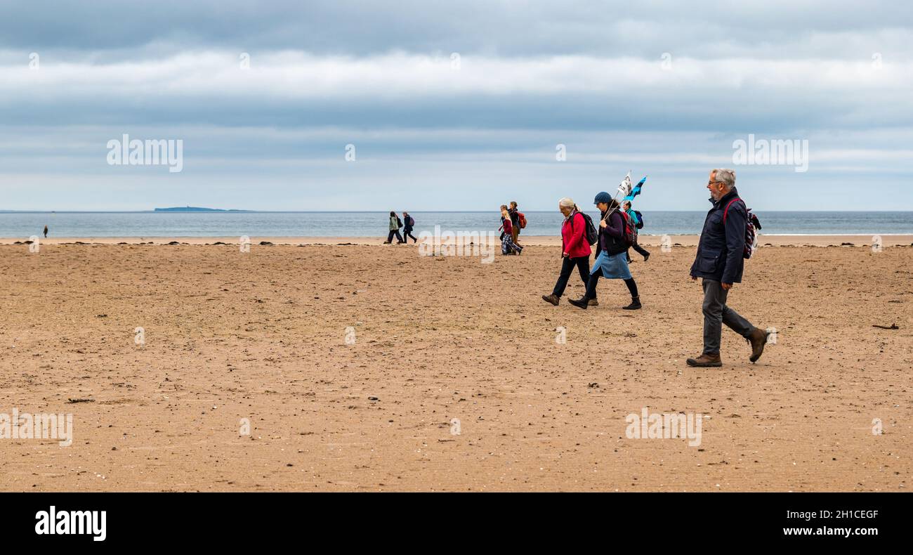 Belhaven Bay, East Lothian, Schottland, Großbritannien, 18. Oktober 2021. Cop26 Pilgerfahrt: Nach einem Zwischenstopp in Dunbar starten christliche Klimaaktivisten auf der ersten Etappe des John Muir Way und wandern bei Ebbe über den Strand. Die Pilgerfahrt wird Ende des Monats zur COP26 in Glasgow gehen Stockfoto