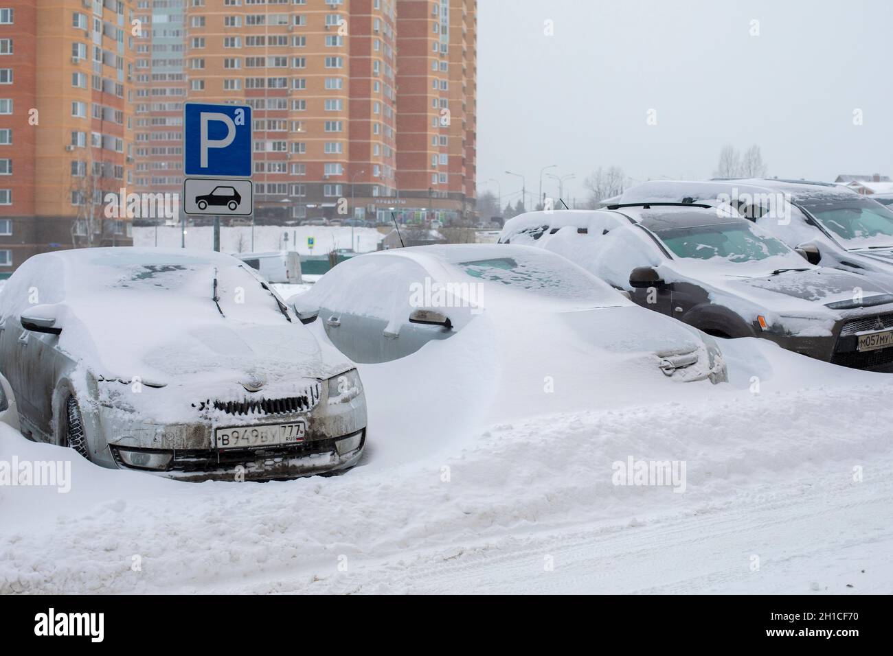 Moskau, Russland - 13. Februar 2021: Parken auf der mit Schnee bedeckten Straße. Auto ertrank im Schnee, abnorme Menge an Schneefall im Winter Stockfoto