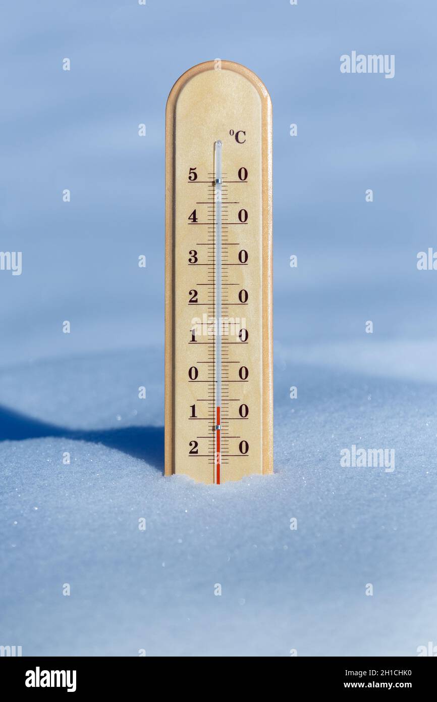 Ein Thermometer im blauen Schnee zeigt eine Temperatur von -7 Grad Celsius Stockfoto