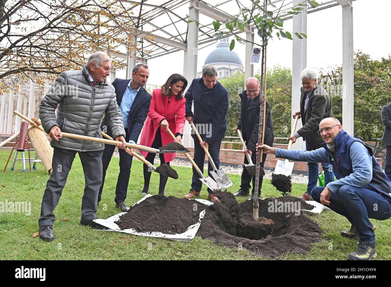 München, Deutschland. 18. Oktober 2021: Von links: Alois GLUECK, Umweltminister Thorsten GLAUBER, Landwirtschaftsministerin Michaela KANIBER, Markus SOEDER (Ministerpräsident Bayern und CSU-Vorsitzender), Norbert Schäfer (Landesverband für Vogelschutz Bayern), Richard MERGNER (Bund Naturschutz Bayern) Pflanzen einen Kirschbaum - eine Hedelfinger-Riesenkirsche. Pressekonferenz der Bayerischen Staatsregierung zum Thema Ergebnisse nach dem Rundtisch STREUOBST am 18. Oktober 2021 im Hofgarten in München. Quelle: dpa picture Alliance/Alamy Live News Stockfoto